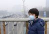 Asian child protects himself against air pollution by wearing mouth mask for children