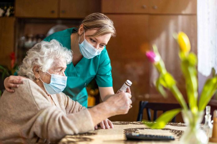 Home care specialist in New Zealand assists an elderly woman reading her medication label